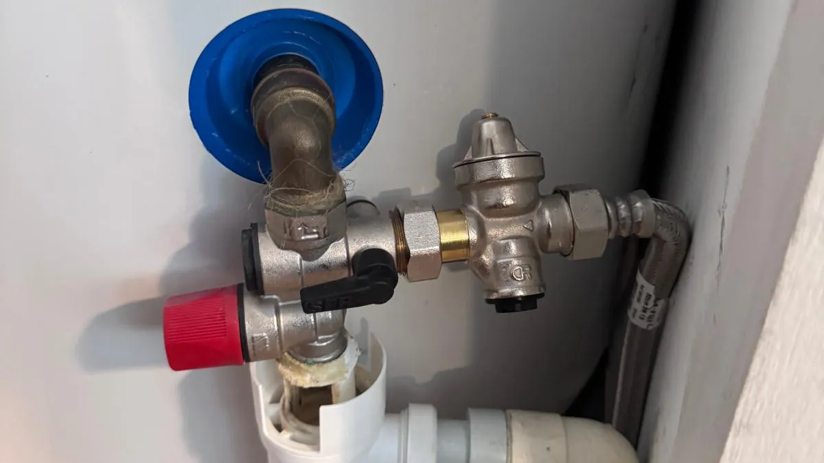 Groupe de sécurité et réducteur de pression raccordés sous un chauffe-eau électrique